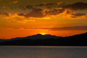 Sun setting behind mountains photo