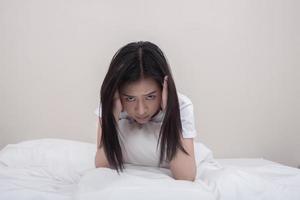 Depressed young woman sitting in bed photo