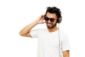 Hombre guapo asiático sonriendo y escuchando música con auriculares foto