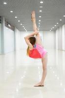 Gymnast doing a vertical split in a bright room photo