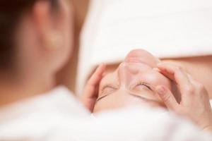 mujer recibiendo masaje facial profesional foto