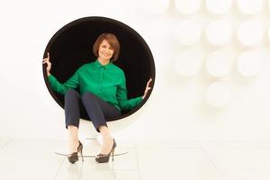 Woman sitting on a spherical chair photo