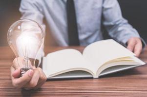 Businessman with notebook and light bulb photo