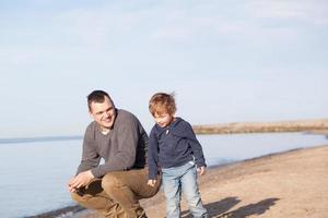 padre con su hijo pequeño en la playa foto