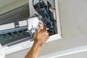 Service technician is cleaning air conditioner photo