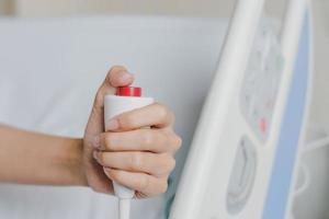 Close-up of patient hand pressing emergency button photo