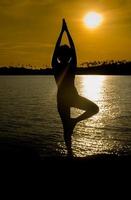 Portrait of a young woman as a silhouette by the sea photo