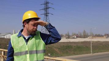 werknemer in een helm staat op de brug video