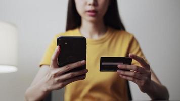 mujer sosteniendo un teléfono inteligente y una tarjeta de crédito video