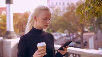 portret blonde maakt gebruik van telefoon in de stad video