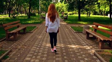 Female with red hair strolls in the city video
