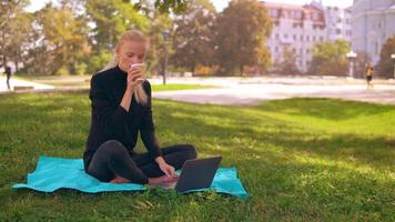 ragazza bionda utilizza il computer all'aperto video