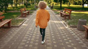 Blonde female walks in city park