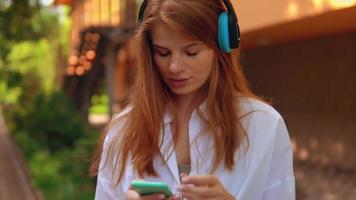stående ung kvinna som lyssnar på musik utomhus video