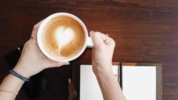 Nahaufnahme Hände der Frau, die eine Tasse Kaffee hält. video