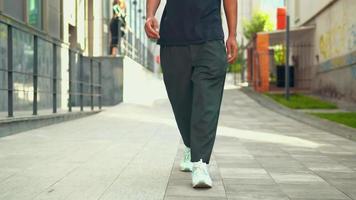 Primer plano de las piernas de un chico hipster caminando en la ciudad video