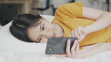 vrouw liggend op het bed en met behulp van een smartphone video