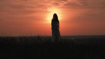 donna in un paesaggio di campagna durante il tramonto video