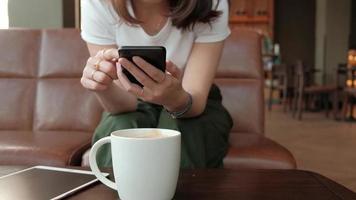 mujer asiática con un teléfono inteligente. video