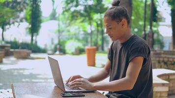 Homme jeune hipster fatigué travaille sur un ordinateur portable à l'extérieur video