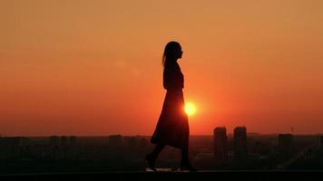 mujer camina delante del paisaje urbano al amanecer video