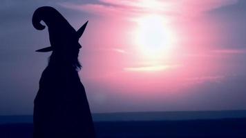 Woman in a witch costume offers a magic apple video
