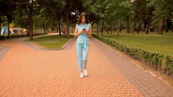 La empresaria con smartphone caminando sobre zona peatonal