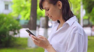kaukasisk kvinna som chattar online i parken