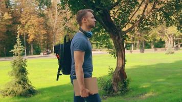 Un chico con ropa casual camina en un parque de la ciudad. video