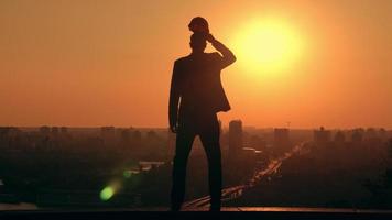 architetto maschio che mette su un cappello duro al lavoro scenico città video