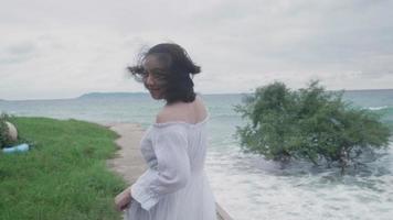 slow motion Aziatische vrouw draait zich om en lacht op het strand video