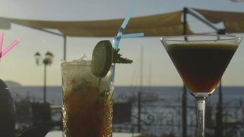 Multiple cocktails on a bar with sunset in the background video