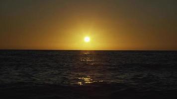 Sun setting  paints the sky yellow at the sea video