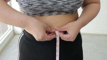 mulher medindo a cintura com uma fita adesiva video