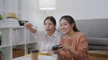 Asian woman sitting and holding joystick.