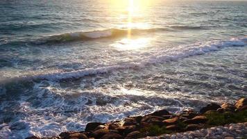rochas e mar e o pôr do sol video