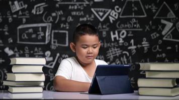 garçon asiatique apprend en ligne via tablette