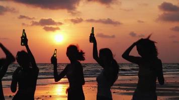 silueta de grupo bebiendo con un fondo de puesta de sol.