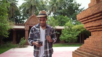 Vista frontal del turista masculino africano visitando un templo de Tailandia video