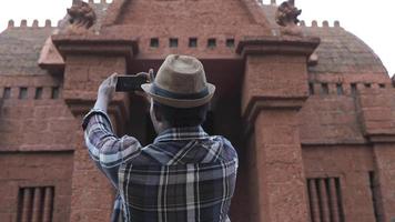 jeune touriste masculin prenant des photos avec un smartphone.