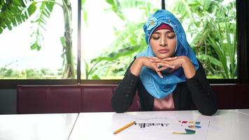 ernsthafte arabische junge Frau, die am Tisch mit zusammenfassendem Dokument sitzt video
