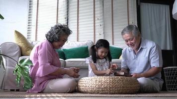 Happy asian family playing puzzle games at home. video