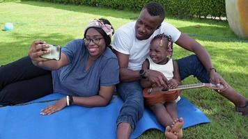 Famille afro-américaine, passer du temps ensemble dans le jardin par une journée ensoleillée video