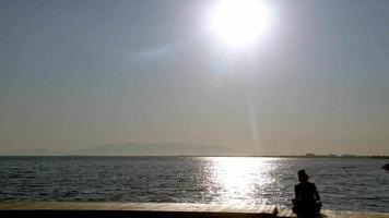 Lonely Woman Sitting on a Wooden Bench By the Ocean video