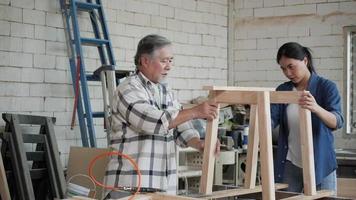 homem asiático e mulher encaixando peças de madeira em uma garagem.