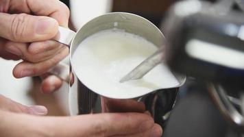 Barista mit Kaffeemaschine zum Dämpfen von Milch