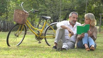 una coppia che legge un libro nel parco video