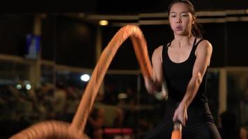 Athletic woman swing ropes at gym. video