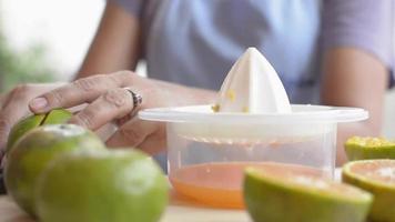 fermer les mains pressant les oranges dans un presse-agrumes manuel. video