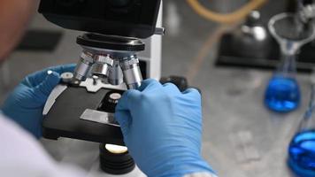 Young scientist looking through a microscope video